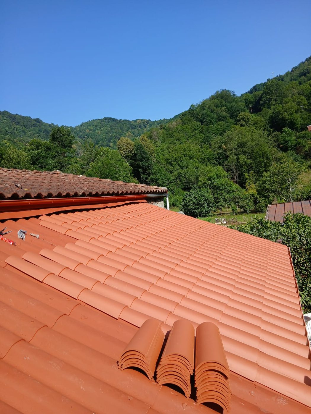 Toiture en tuiles de terre cuite rénovée, vue sur la vallée
